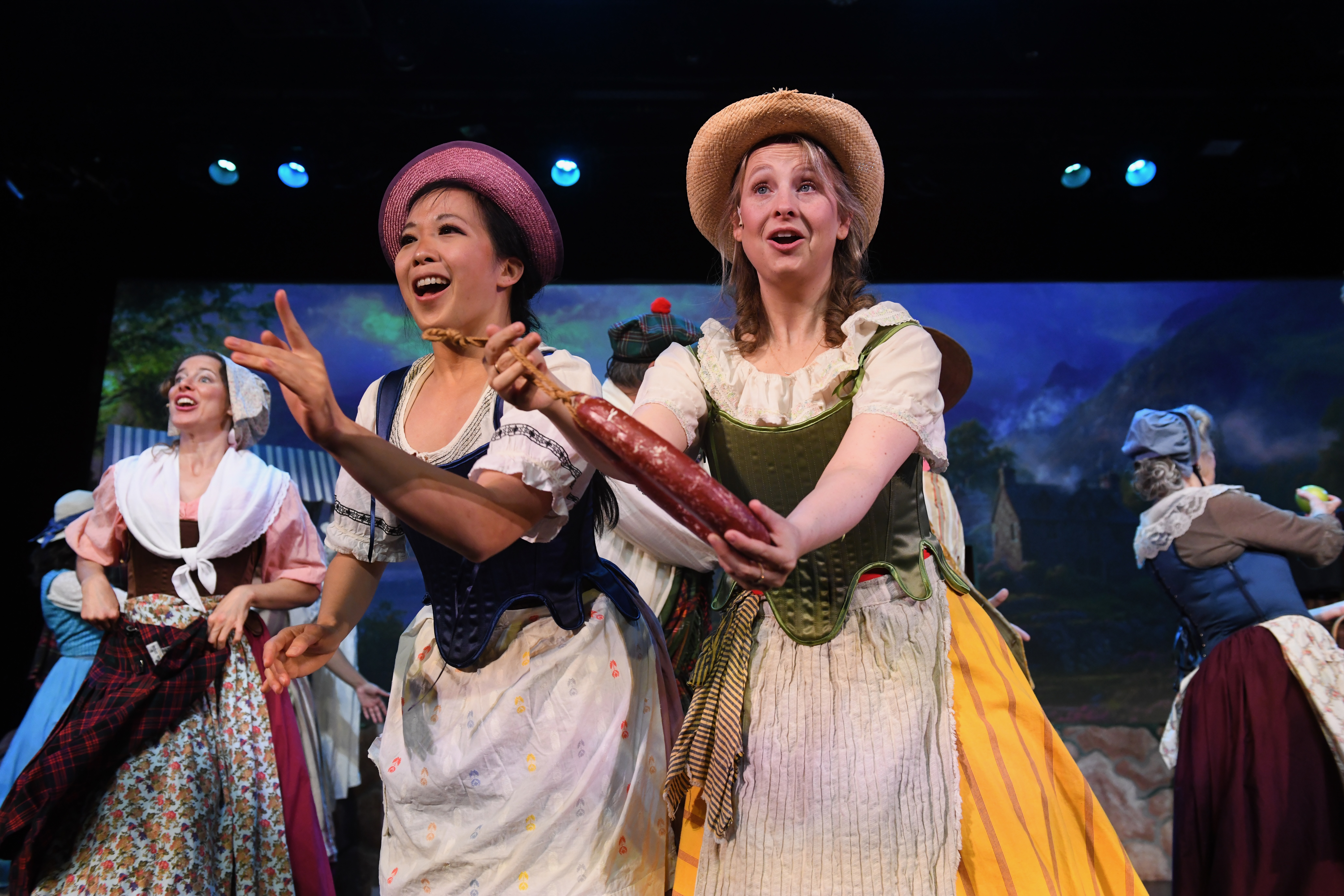 2 girls showing the meat they're selling